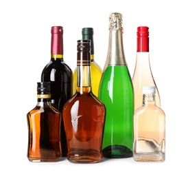 Bottles with different alcoholic drinks on white background