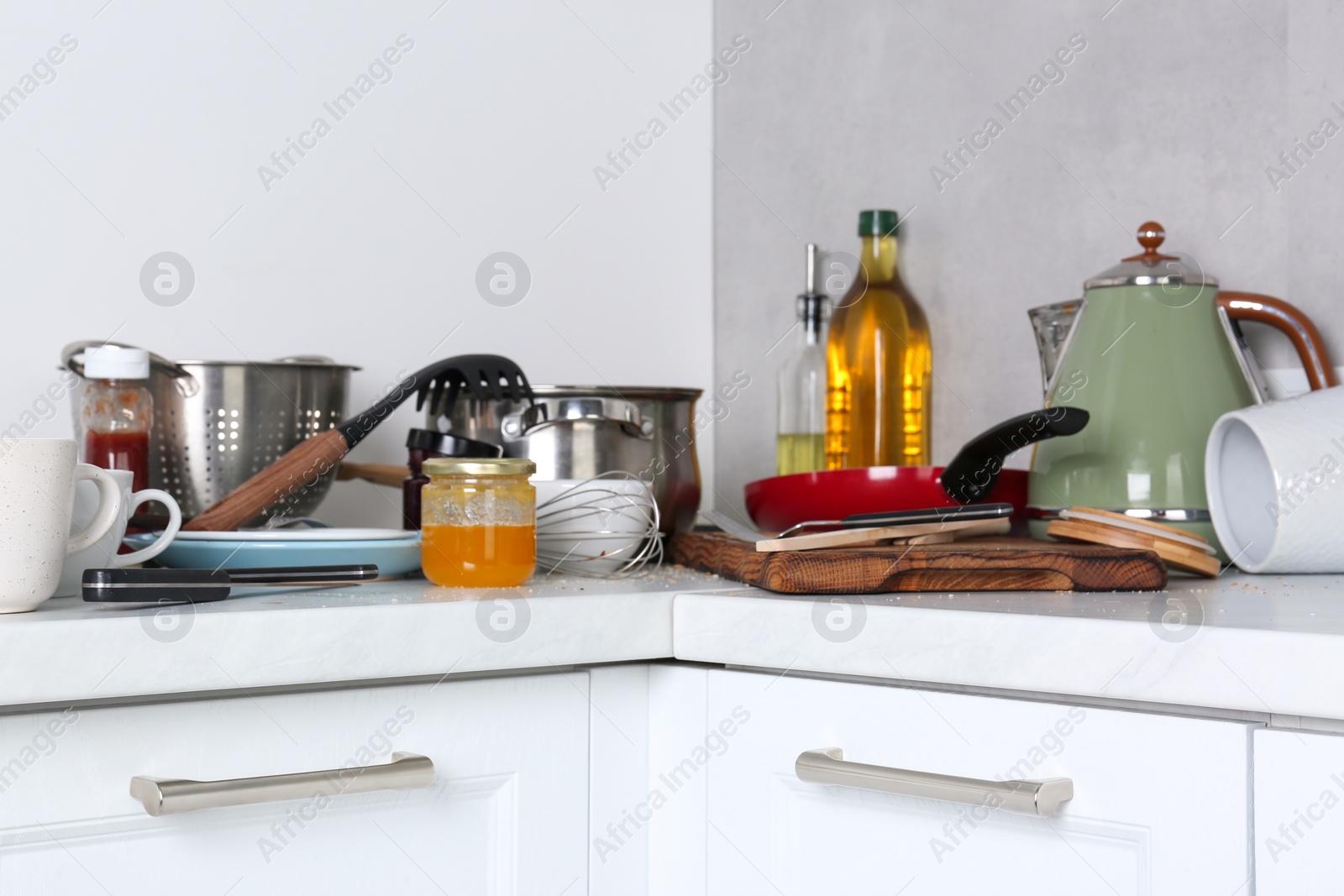 Photo of Many dirty utensils, cookware and dishware on countertop in messy kitchen