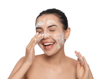 Happy young woman washing face with cosmetic product on white background