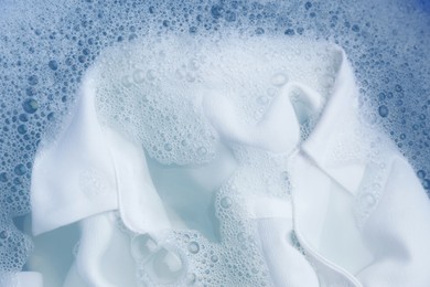 White clothing in suds, top view. Hand washing laundry