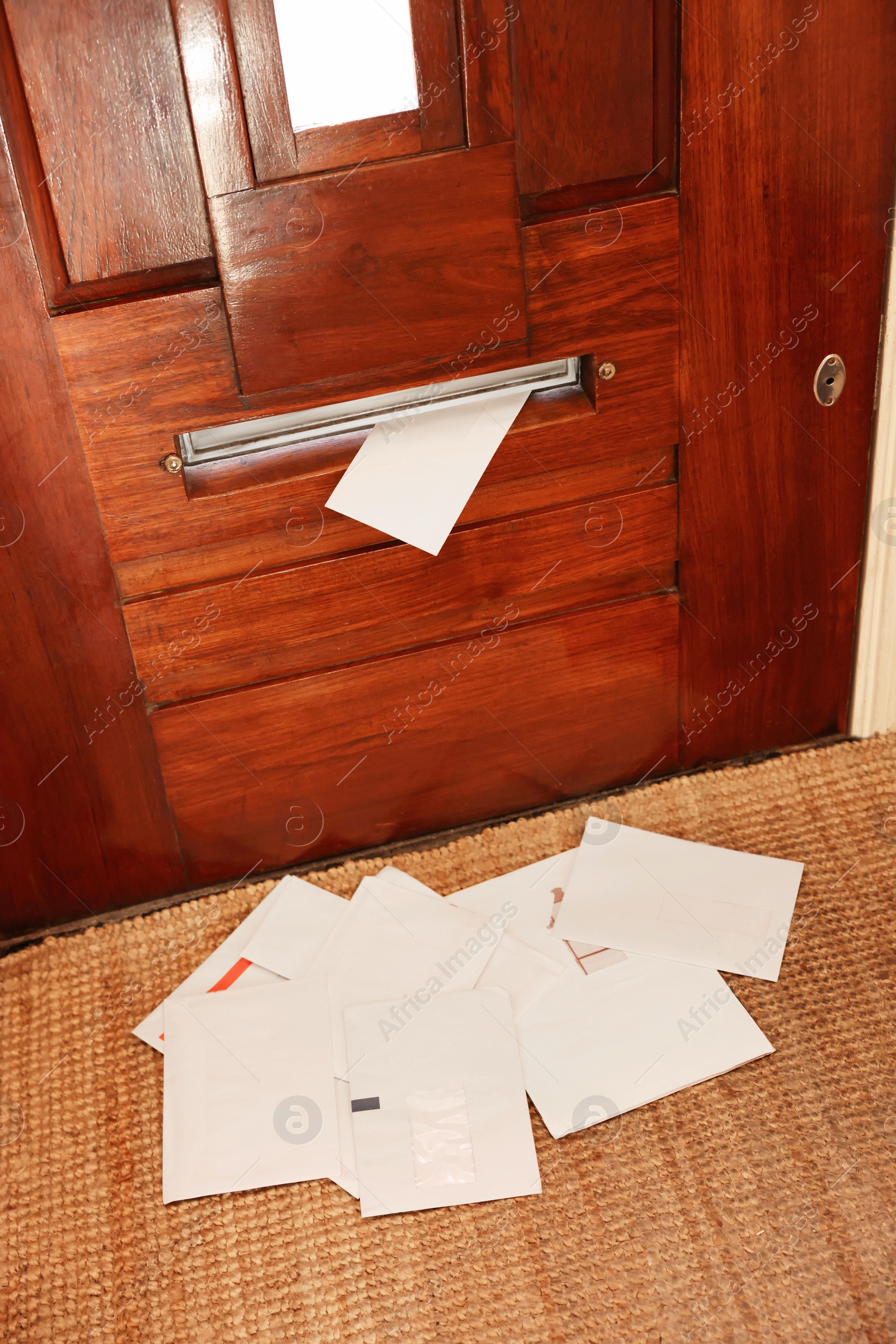 Photo of Wooden door with mail slot and many envelopes indoors, above view