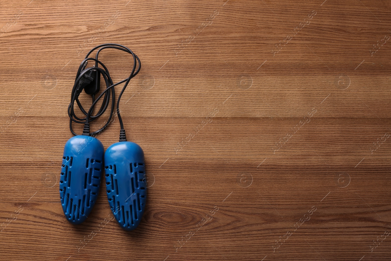 Photo of Electric shoe dryer on wooden background, top view. Space for text