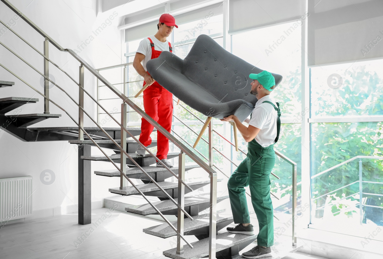 Photo of Male movers carrying sofa in new house