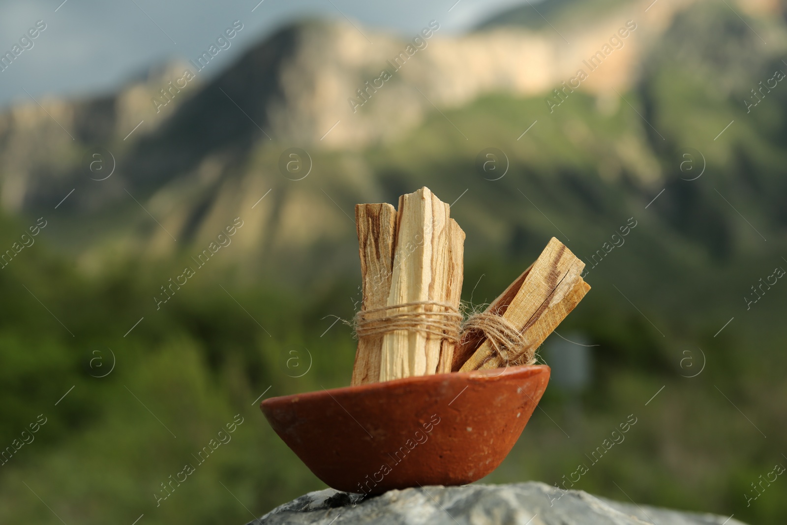 Photo of Many palo santo sticks on stone surface in high mountains, closeup