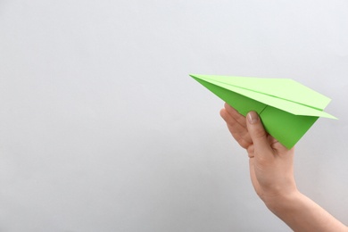 Photo of Woman holding paper plane on white background, closeup. Space for text