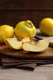 Photo of Ripe whole and cut quinces on table