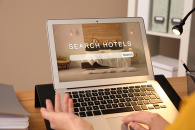 Image of Woman searching hotel using laptop at table, closeup. Booking online service