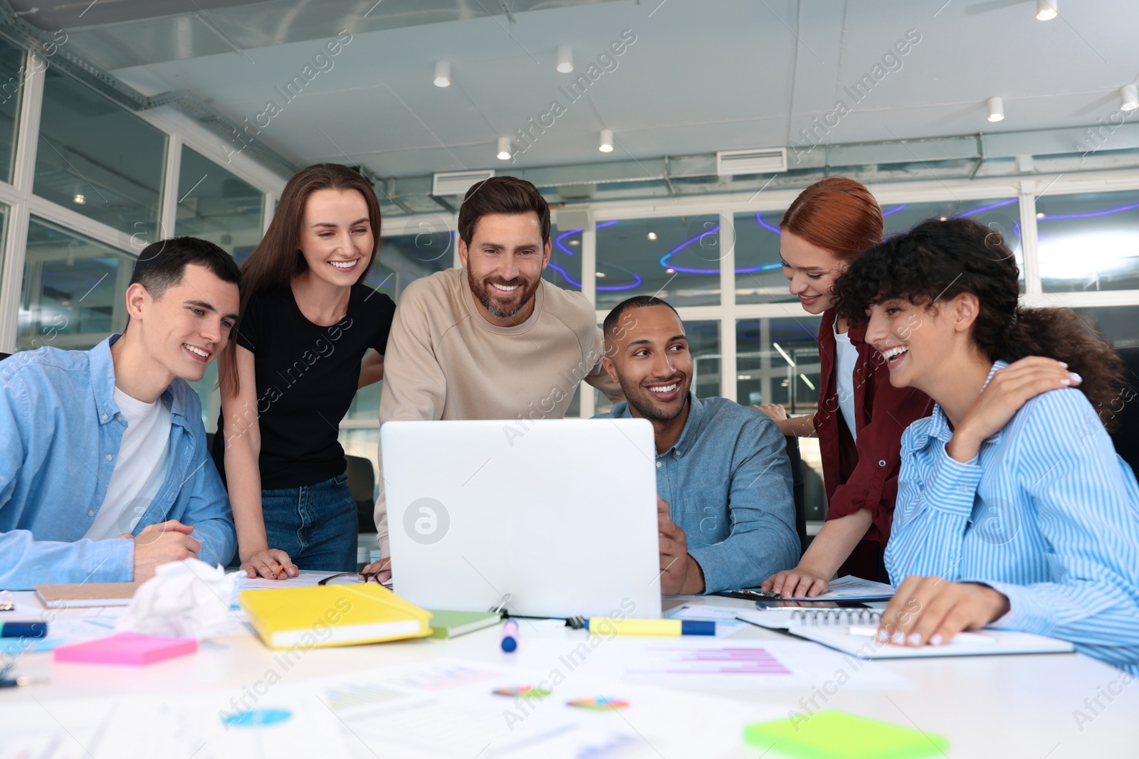 Photo of Team of employees working together at table in office. Startup project