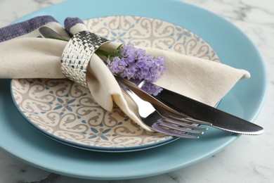 Photo of Stylish setting with cutlery and plates on white marble table, closeup