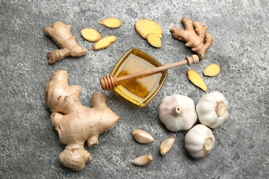 Photo of Ginger and other natural cold remedies on grey table, flat lay
