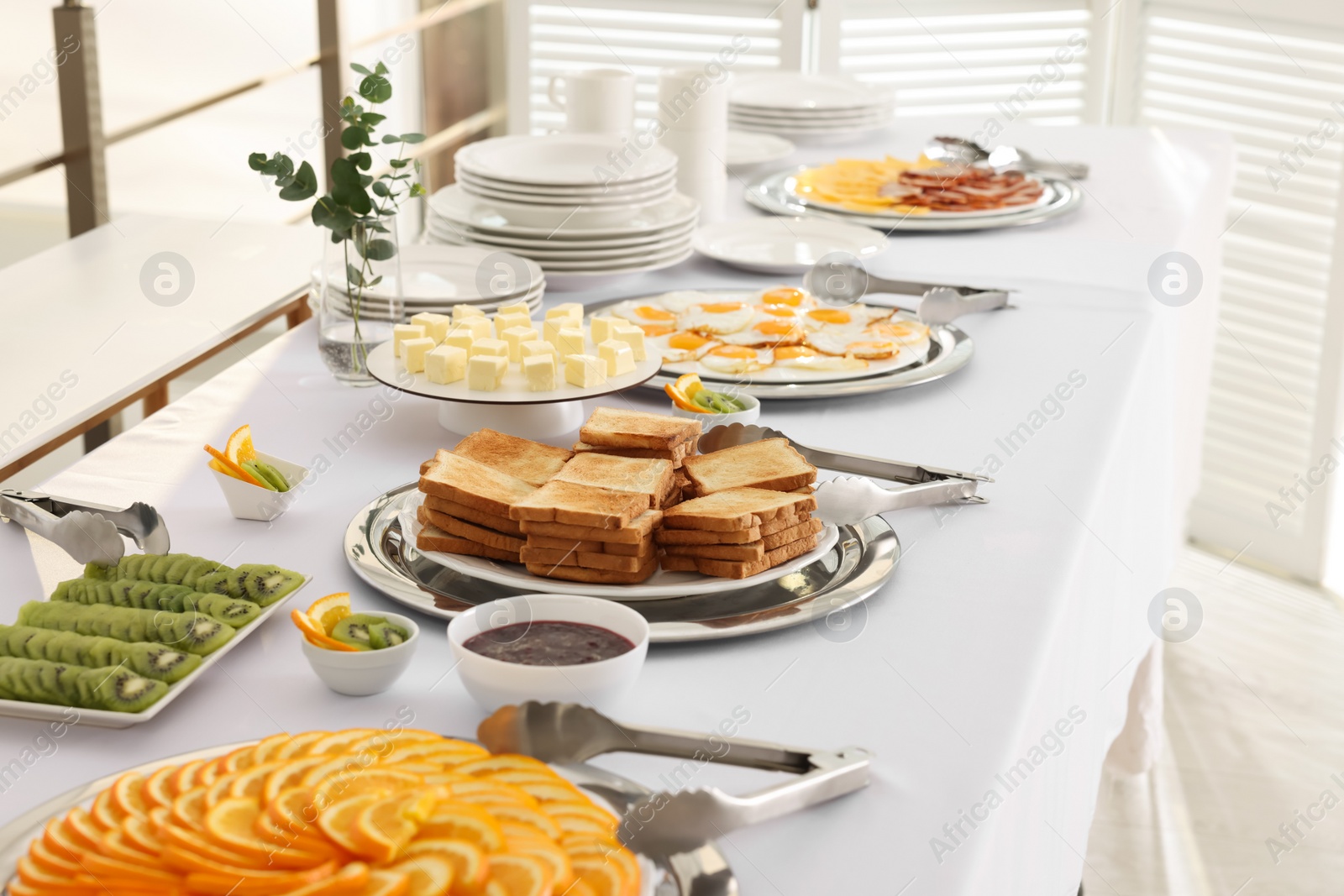 Photo of Different meals for breakfast on white table indoors. Buffet service