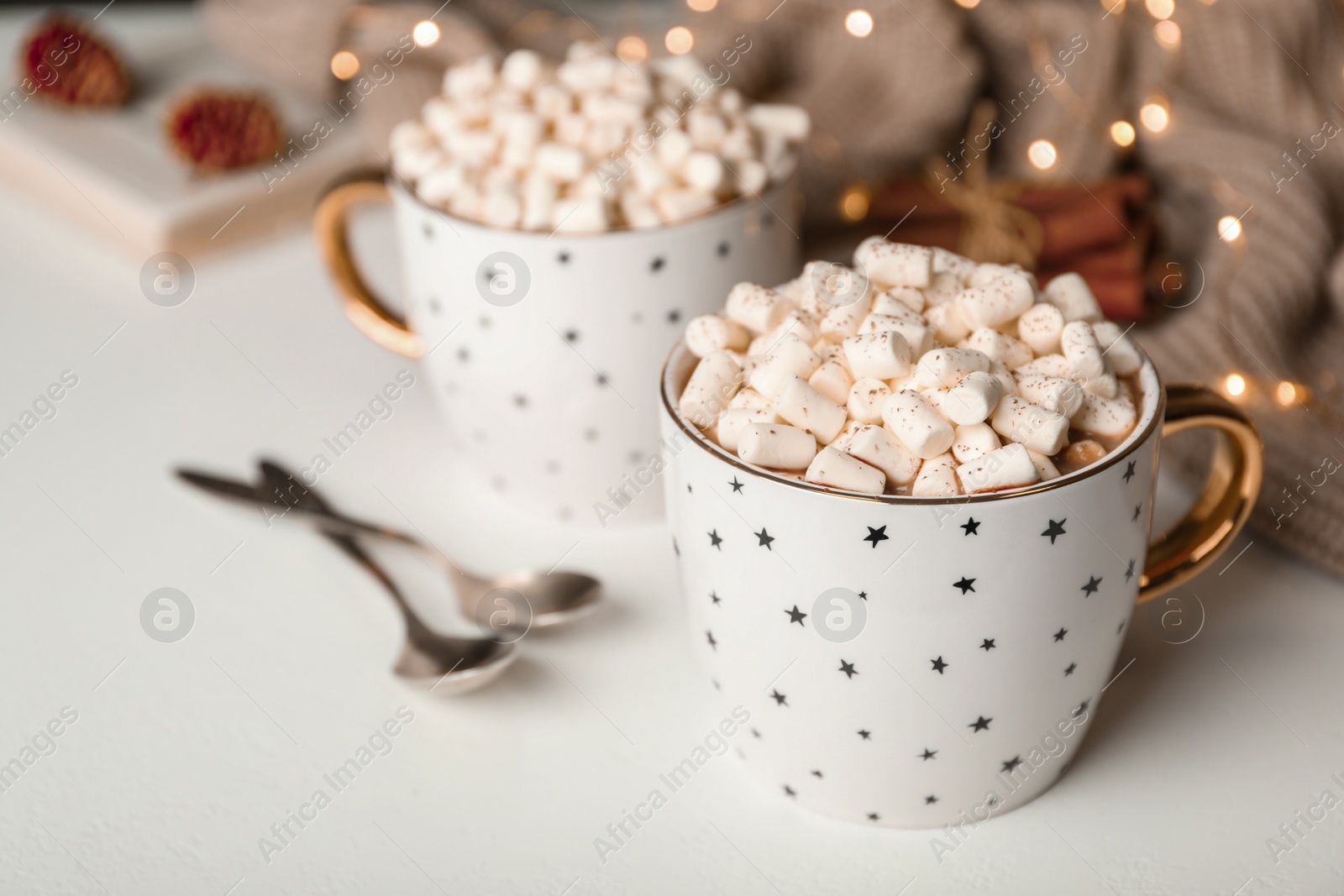 Photo of Delicious cocoa drink with marshmallows on white table, space for text