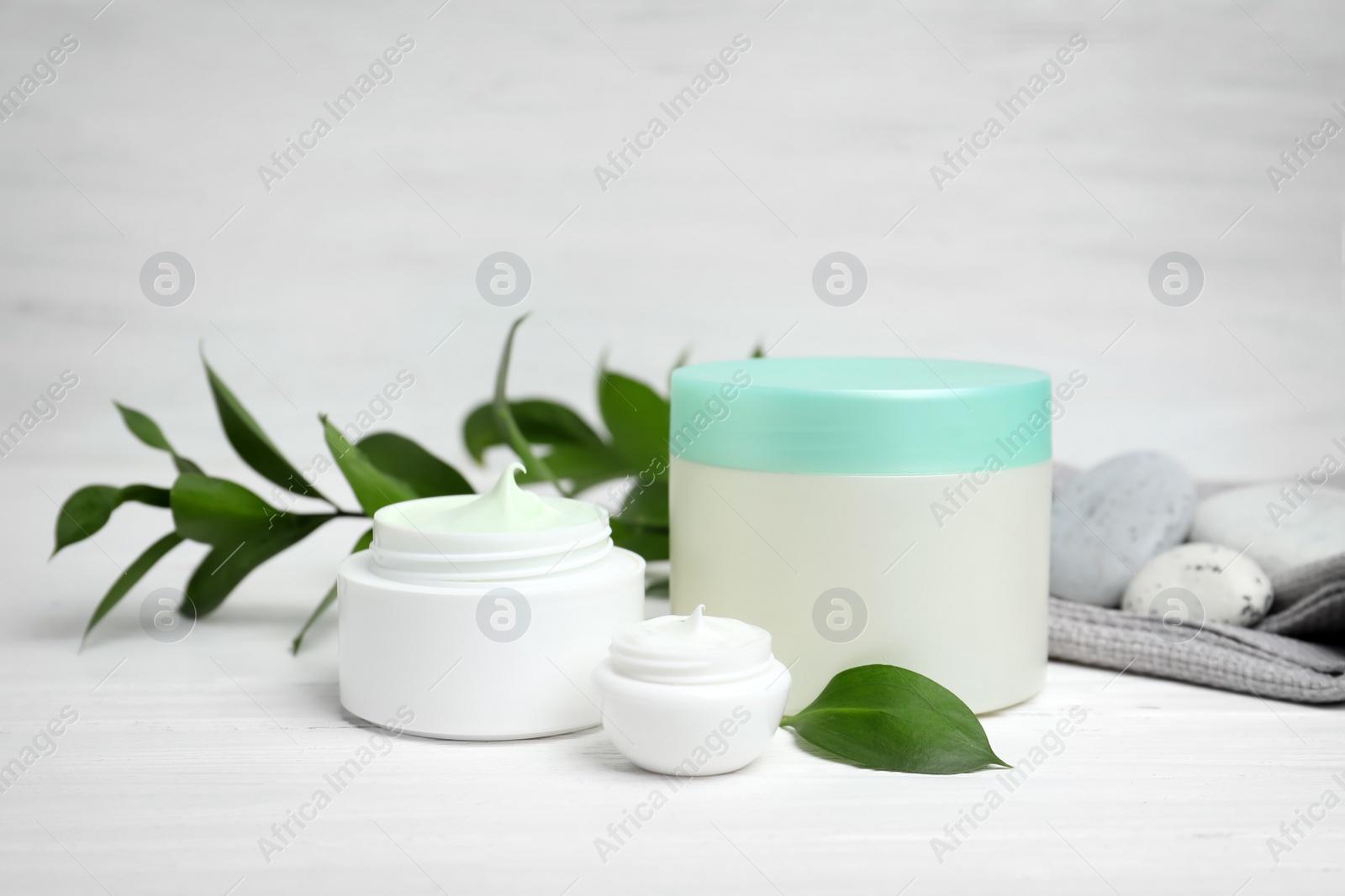 Photo of Composition with body cream in jars on light background