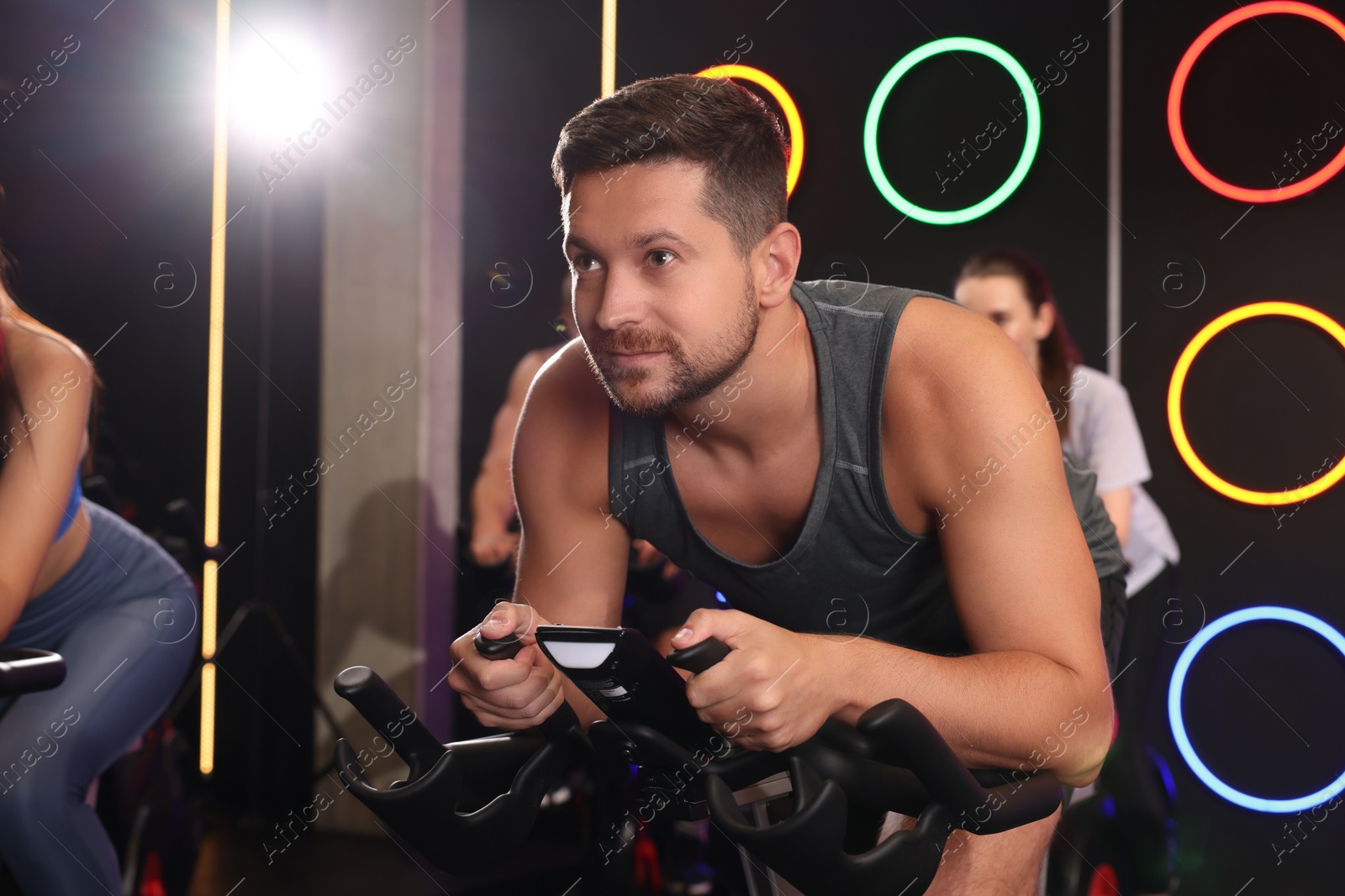 Photo of Group of people training on exercise bikes in fitness club