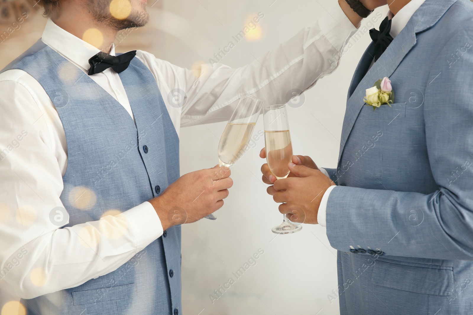 Photo of Newlywed gay couple with glasses of champagne at home, closeup