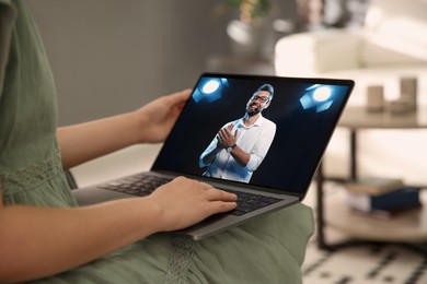 Image of Woman watching performance of motivational speaker on laptop indoors, closeup