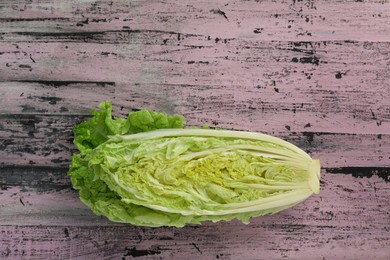 Photo of Cut fresh ripe Chinese cabbage on rustic table, top view. Space for text