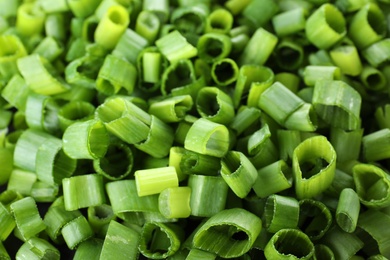 Photo of Cut fresh green onions as background, closeup