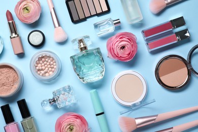 Flat lay composition with different makeup products and beautiful spring flowers on light blue background