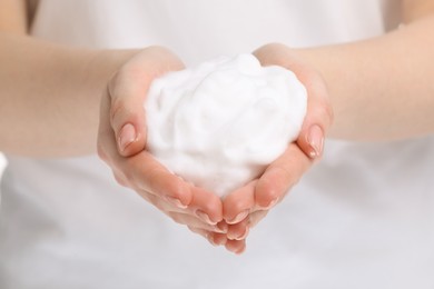 Woman with bath foam on white background, closeup