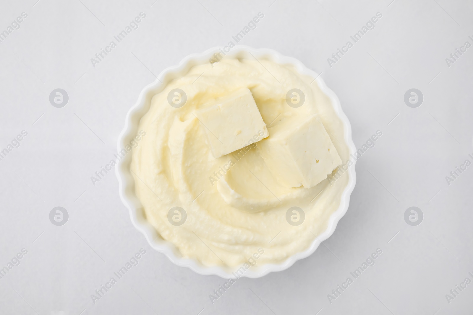 Photo of Delicious tofu sauce in bowl on white tiled table, top view