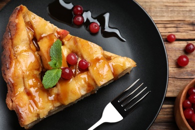 Slice of traditional apple pie with berries on wooden table, flat lay