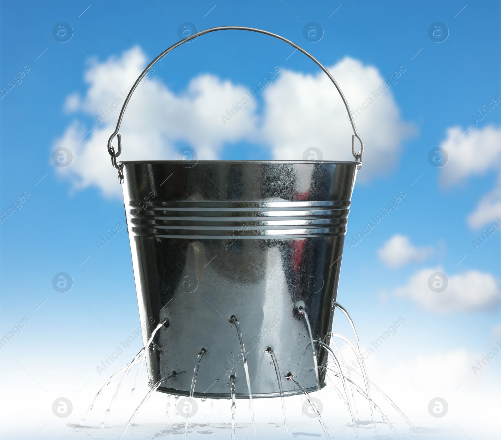 Image of Leaky bucket with water against blue sky