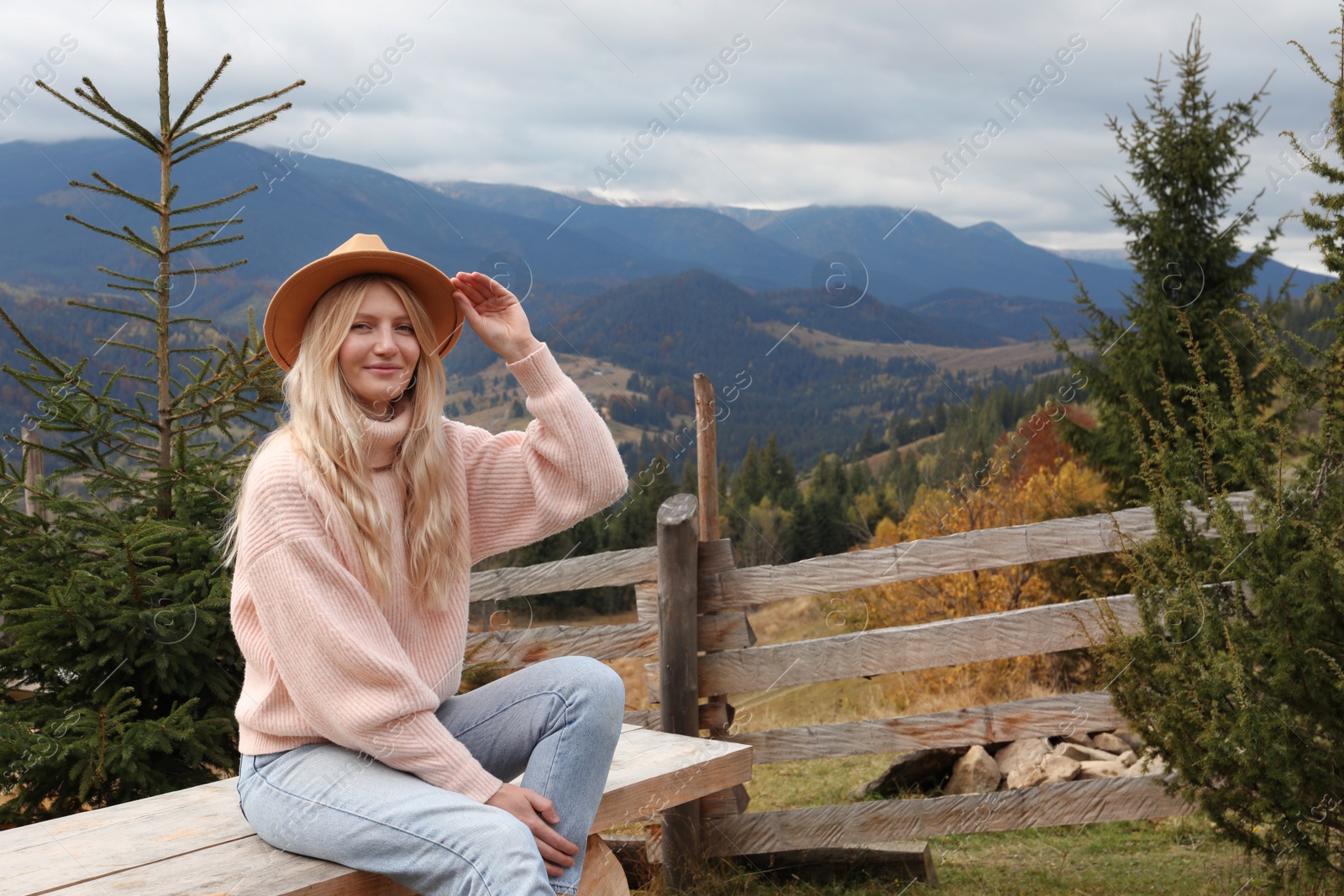 Photo of Beautiful young woman in mountains on autumn day, space for text