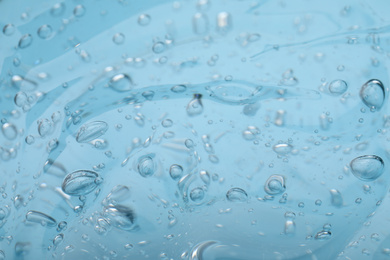 Photo of Sample of light blue cosmetic gel as background, closeup