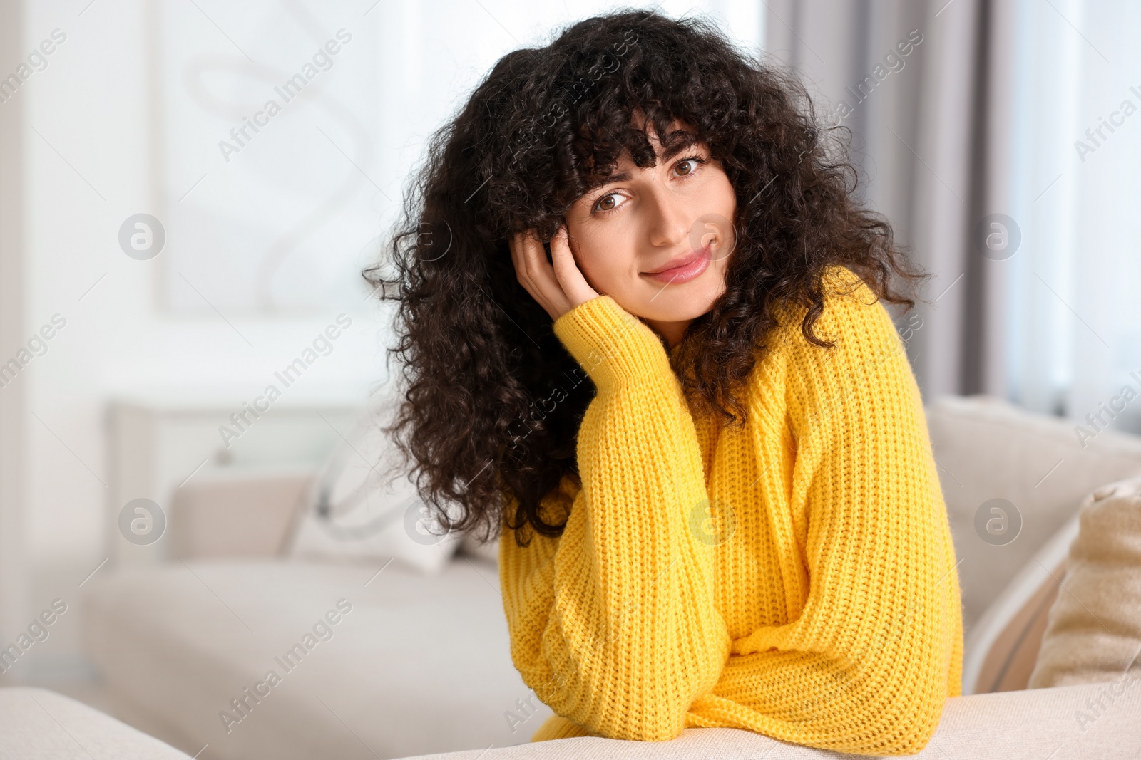 Photo of Young woman in stylish yellow sweater indoors, space for text