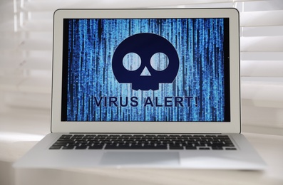 Photo of Laptop with warning about virus attack on window sill