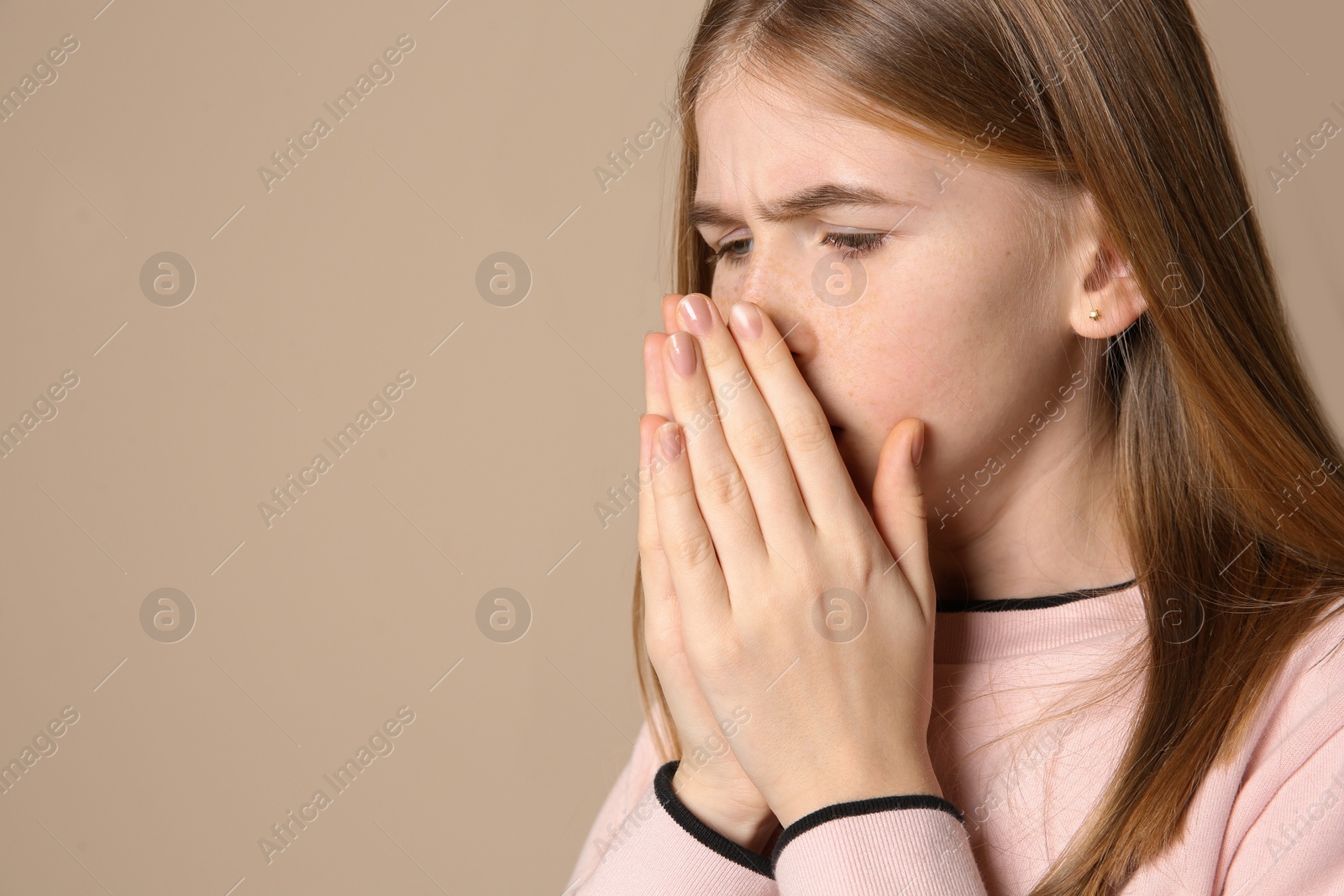 Photo of Teenage girl suffering from cough on color background. Space for text