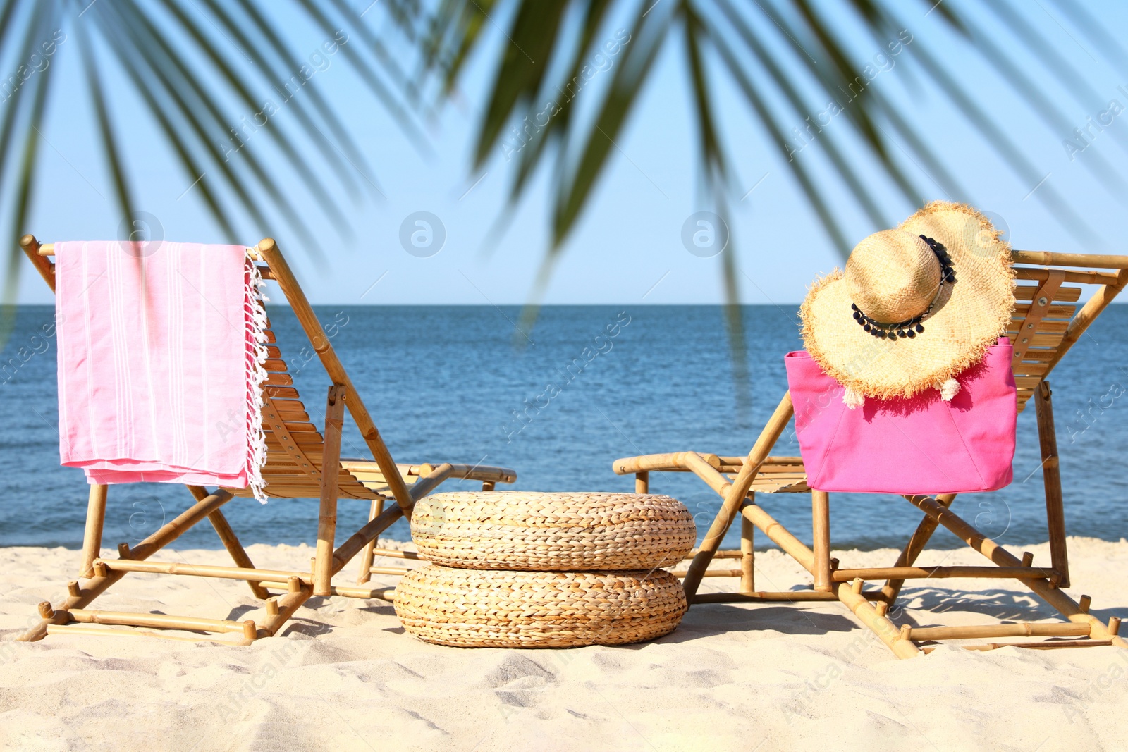 Photo of Wooden sunbeds and beach accessories on sandy shore