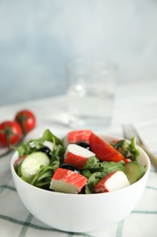 Photo of Tasty crab stick salad served on table, closeup. Space for text