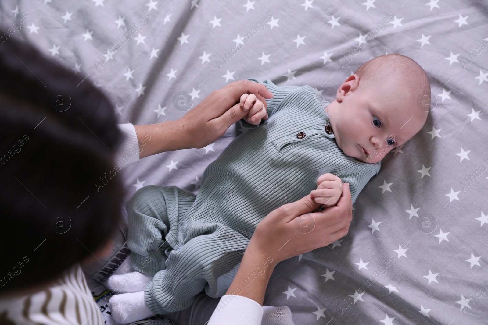 Photo of Mother and with her little baby on bed, above view