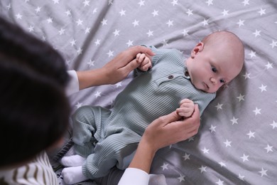 Photo of Mother and with her little baby on bed, above view