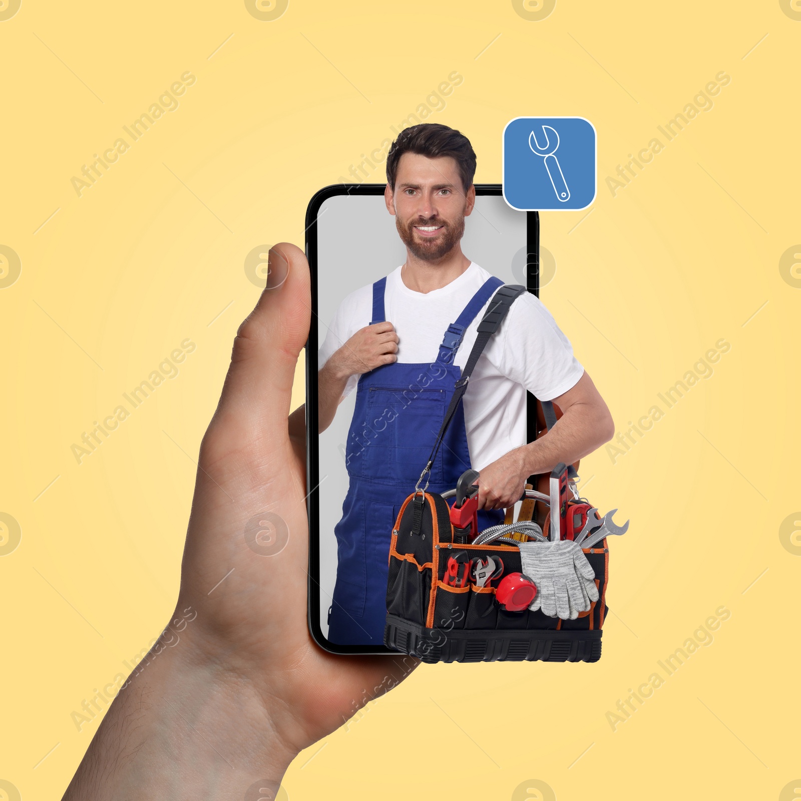 Image of Find plumber. Man using mobile phone on light yellow background, closeup. Specialist looking out of gadget
