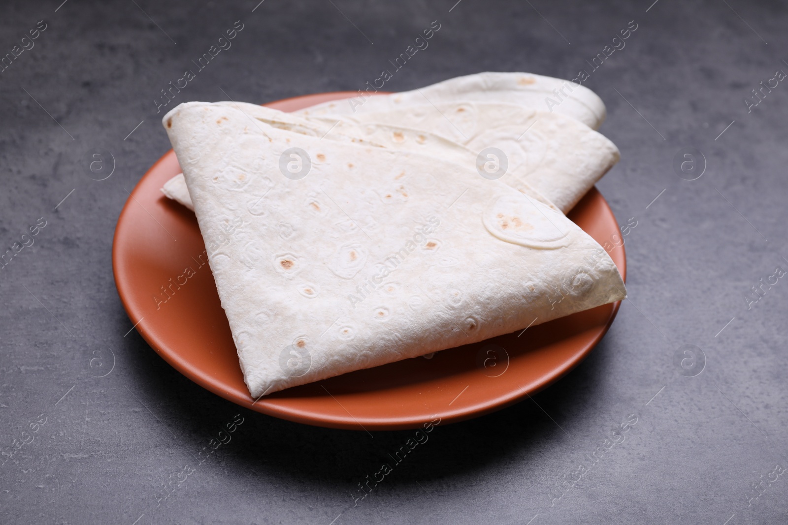 Photo of Delicious folded Armenian lavash on dark table