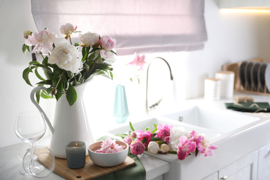 Photo of Beautiful kitchen counter design with fresh peonies