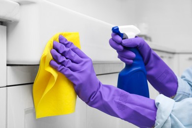 Photo of Woman cleaning white surface with rag and detergent indoors, closeup