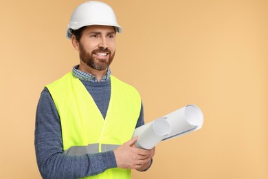 Architect in hard hat with drafts on beige background, space for text