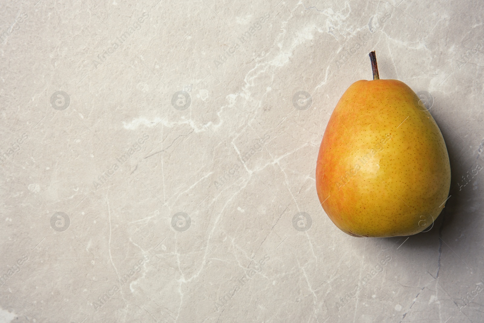 Photo of Ripe pear on grey background, top view. Space for text