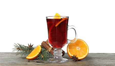 Photo of Composition with glass cup of mulled wine, cinnamon, orange and fir branch on table against white background