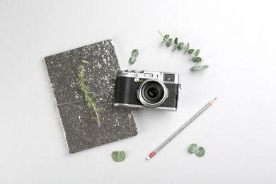 Photo of Flat lay composition with camera for professional photographer and stationery on light background
