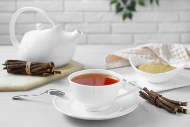 Photo of Aromatic licorice tea in cup served on white table