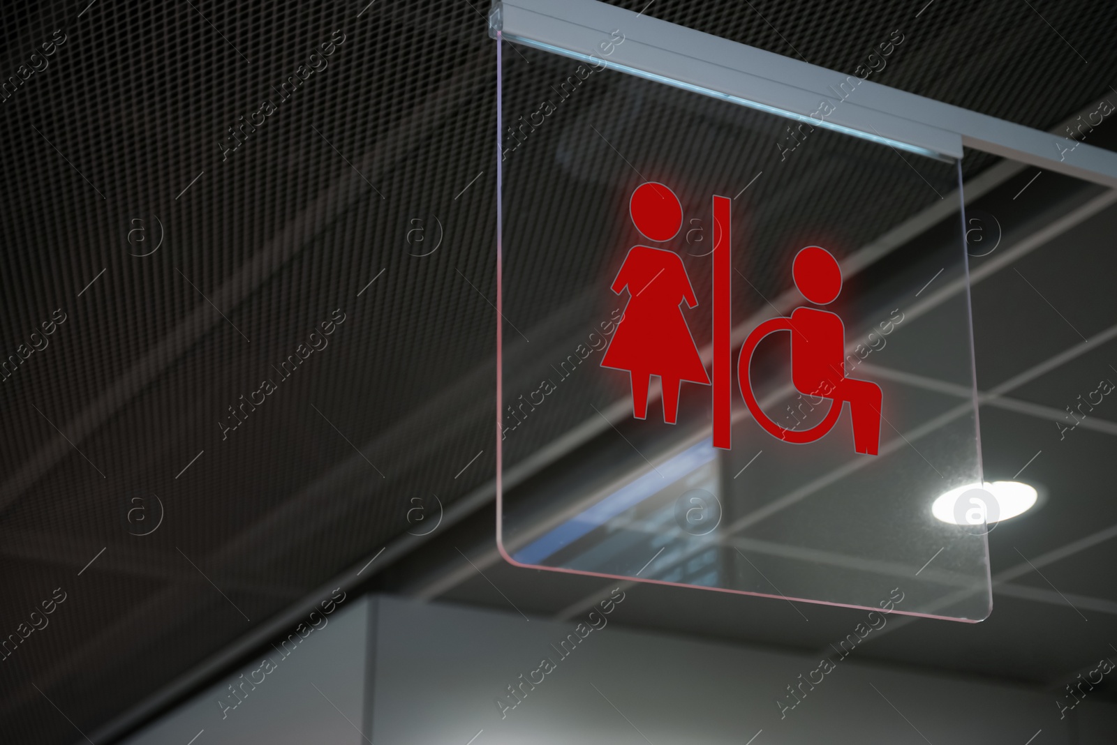 Image of Red public toilet sign on transparent glass hanging indoors