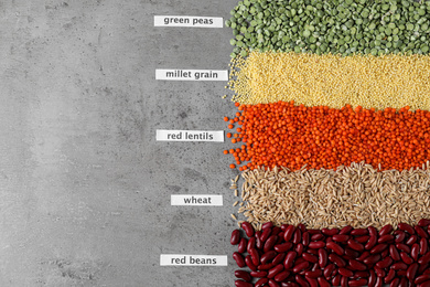 Photo of Flat lay composition with different types of legumes and cereals on grey table. Organic grains