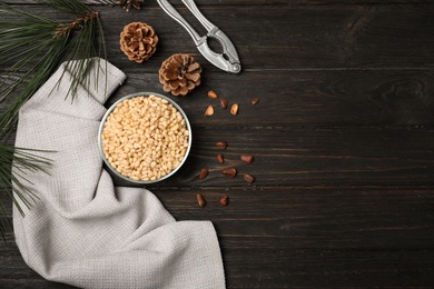 Flat lay composition with pine nuts on wooden background. Space for text