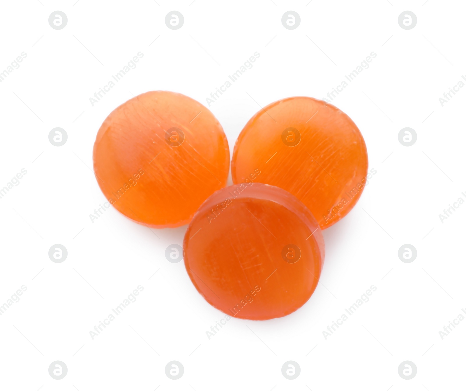 Photo of Orange cough drops on white background, top view