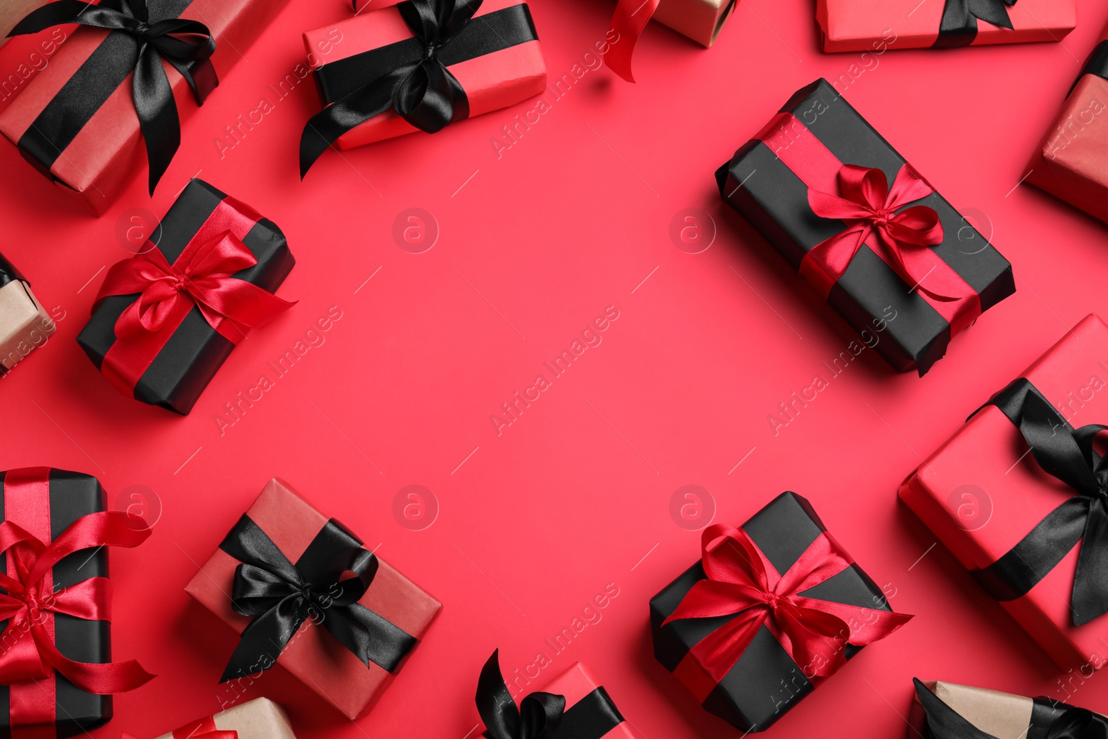 Photo of Frame of gift boxes on red background, flat lay with space for text. Black Friday sale